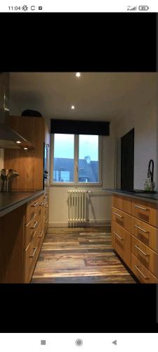 Il comprend une grande cuisine dotée de parquet et d'une grande fenêtre. dans l'établissement Appartement de style à l'exceptionnelle vue mer !!, à Le Relecq-Kerhuon