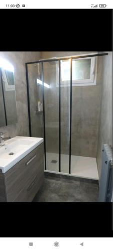 La salle de bains est pourvue d'une douche et d'un lavabo blanc. dans l'établissement Appartement de style à l'exceptionnelle vue mer !!, à Le Relecq-Kerhuon