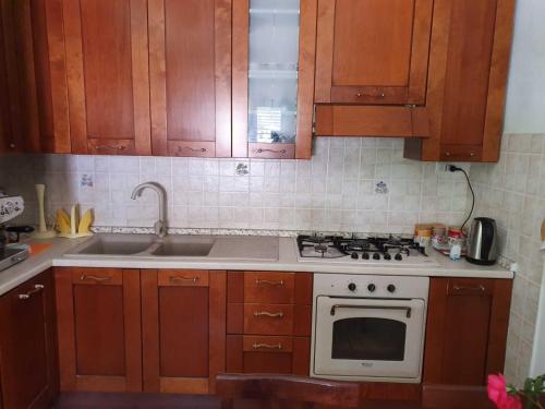 een keuken met houten kasten en een witte kookplaat bij Casa Vacanza Luca in Vulcano