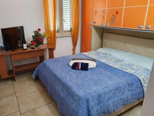 een slaapkamer met een bed, een bureau en een televisie bij Casa Vacanza Luca in Vulcano