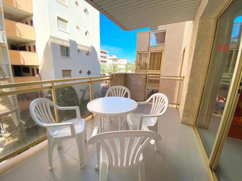 - Balcón con mesa blanca y sillas en Apartamentos Amatista, en Salou