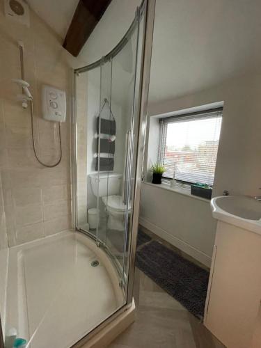 a bathroom with a shower and a toilet and a sink at Flat 2 Chestergate in Macclesfield