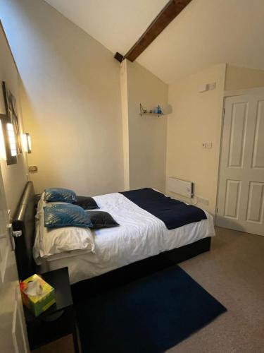 a bedroom with a large bed with blue pillows at Flat 2 Chestergate in Macclesfield