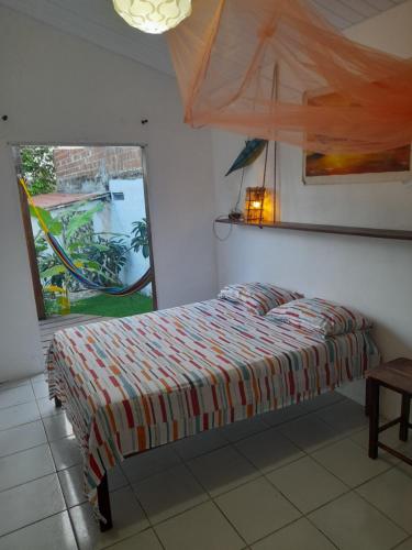 a bedroom with a bed and a large window at Hopa Shelter Surf House Apartamento in Paracuru