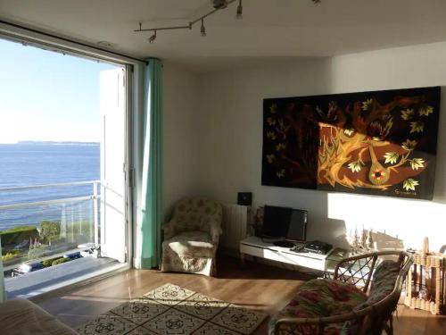 un salon avec une grande fenêtre avec vue sur l'océan dans l'établissement EXCEPTIONNEL 3PIÈCES, BALCON, TERRASSE FACE MER, à Villerville