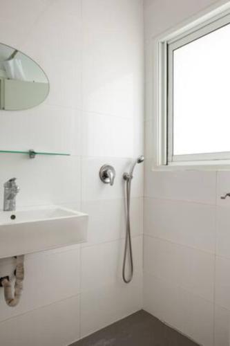 a white bathroom with a sink and a mirror at Oַ&O Group-Amazing APT Bat-Yam 3 Min Walk To Beach in Bat Yam