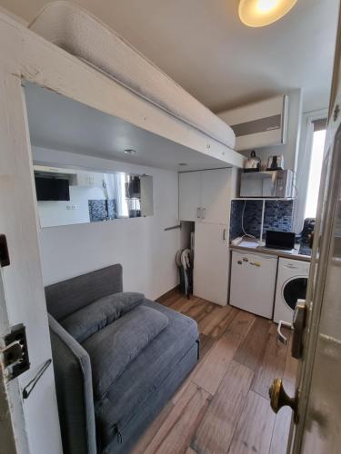 a small living room with a couch and a kitchen at Amazing Studio near Parc des Expositions in Paris