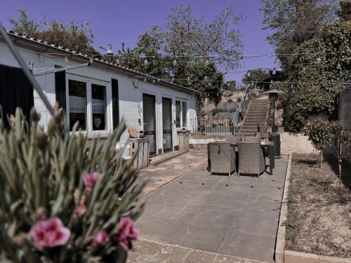 a house with two chairs and flowers in front of it at Loods 123 bed & kitchen in Landgraaf