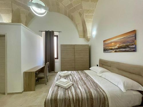 um quarto com uma cama, uma secretária e uma mesa em B&B La Piazzetta em Fragagnano