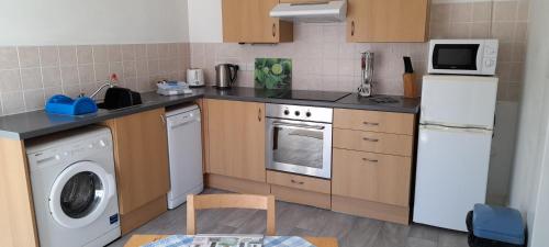 a kitchen with a refrigerator and a washing machine at Little Parklands in Sandown
