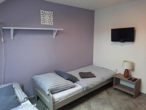 a small bedroom with a bed and a tv at Statek u kapličky in Skalka