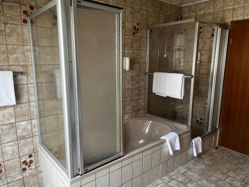 a bathroom with a shower and a bath tub at Hotel Colosseum in Rheinböllen