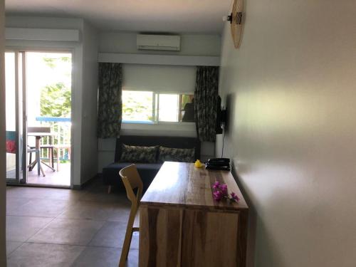 a living room with a wooden table and a couch at CoCoKreyol - Ti CARAYOU in Les Trois-Îlets