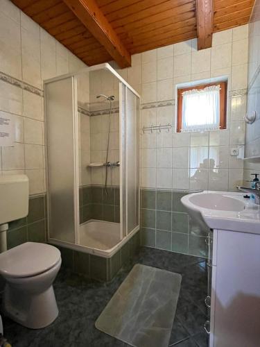 a bathroom with a shower and a toilet and a sink at Magyar Apartmanházak I-III. in Zalakaros