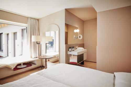 Boutique Hotel das Salz في سالزبورغ: غرفة نوم بسرير ومغسلة ومرآة