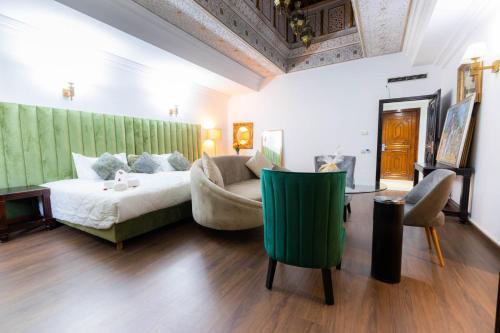 ein Schlafzimmer mit einem Bett, einem Sofa und einem Tisch in der Unterkunft Prince de Paris in Casablanca