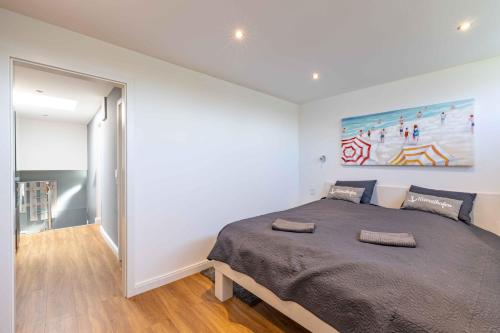 a bedroom with a large bed and a painting on the wall at Beachhouse mit privater Sauna und Kamin, 700m zum Strand in Schönberger Strand