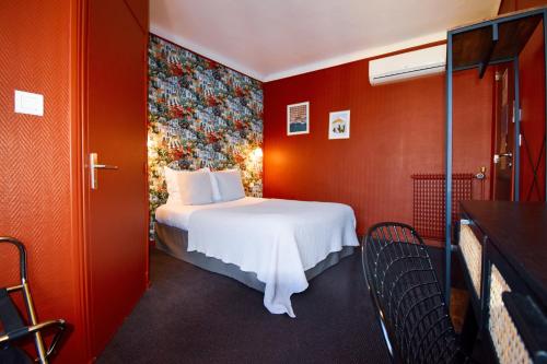a hotel room with a bed and red walls at Hôtel Azur in Reims