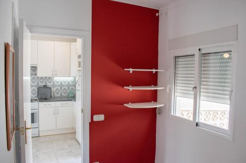 un mur rouge dans une cuisine avec une fenêtre dans l'établissement Casa Fenix, à Calp