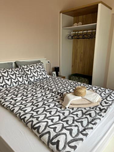 a bed with a black and white comforter and a hat on it at Apartman Maroon - Savršen pogled i miran odmor in Lovran