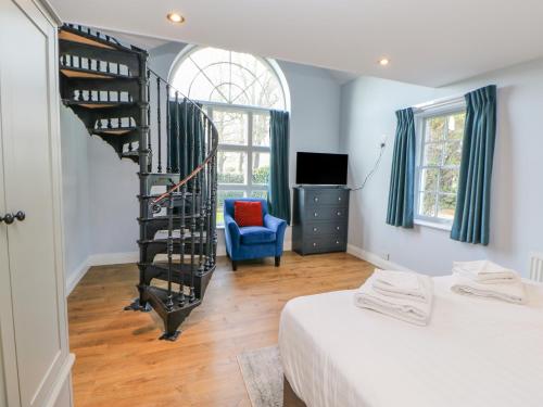 una camera da letto con scala a chiocciola accanto a un letto di Burns Cottage a Barnard Castle