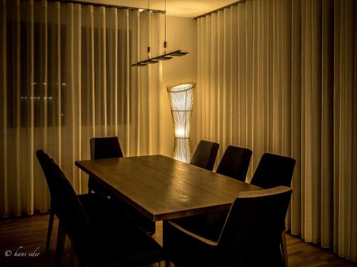 a dining room with a wooden table and chairs at Rooftop Tulln operated by revLIVING in Tulln