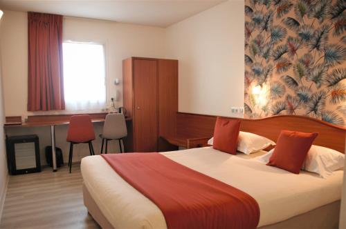 a hotel room with a bed and a desk at Deltour Hotel Le Puy En Velay in Le Puy-en-Velay