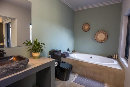 a bathroom with a bath tub and a sink at Muunga Bush Lodge & Spa in Hoedspruit