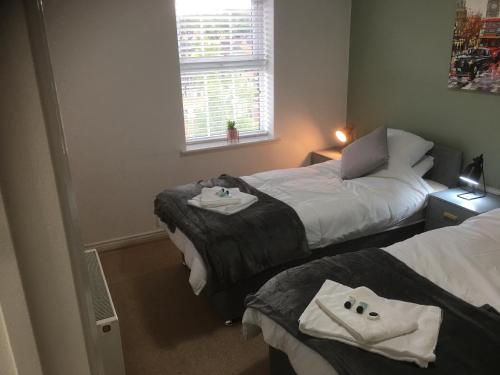 Un dormitorio con dos camas con toallas encima. en Beautiful 2 bed apartment, en Grantham