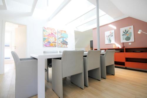 uma sala de jantar com uma mesa branca e cadeiras em Haus Barbara - Schwimmbad und Sauna im Haus-Whg 12 em Grömitz
