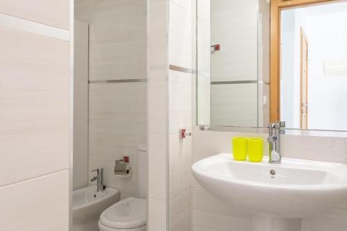 La salle de bains blanche est pourvue d'un lavabo et de toilettes. dans l'établissement Apartment Henri, à El Campello