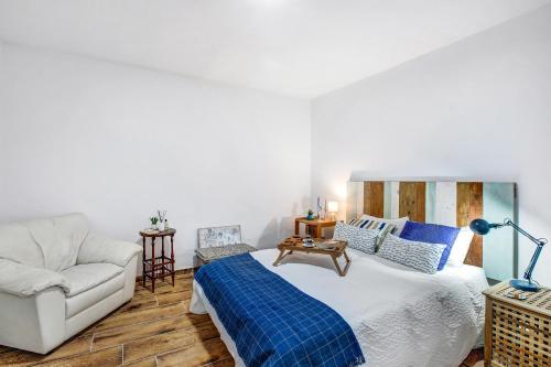 ein Schlafzimmer mit einem Bett und einem Sofa in der Unterkunft Casa Bene in Güímar
