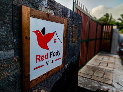 a sign for a red fox village on a fence at Red Fody Villa in Triolet