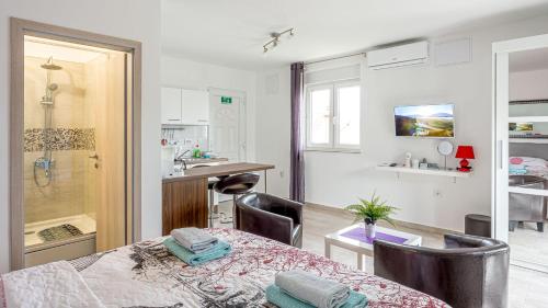 a room with a bed and a kitchen with a sink at Apartments Klara in Senj
