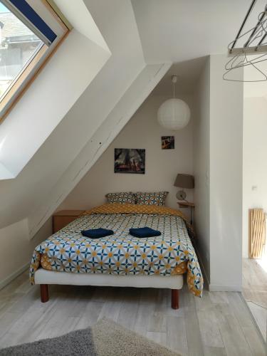 une chambre avec un lit dans un grenier dans l'établissement Chaleureuse petite maison de bourg, à Beaumont-sur-Sarthe