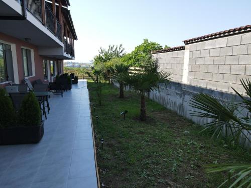 a porch of a house with chairs and trees at Studio 8 Arapya in Tsarevo