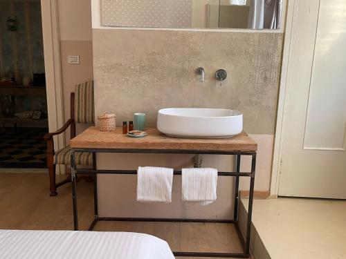 a bathroom with a white sink on a wooden counter at Locanda Garzelli in Quercianella