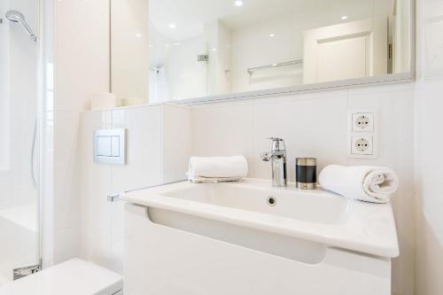 een witte badkamer met een wastafel en een toilet bij Haus Weesterhuk Whg 10 in Keitum