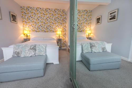 a bedroom with two beds and a mirror at The Sleep-Inn Hare B&B in Herne Bay