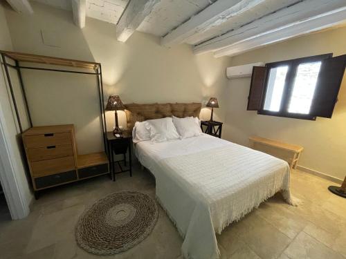 Santa Magdalena de Pulpis的住宿－La Casa del Carrer Major，卧室配有一张白色大床和镜子