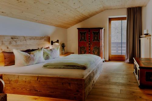 1 dormitorio con cama grande y ventana grande en Ferienwohnung ChiemseeAlpenBlick, en Breitbrunn am Chiemsee