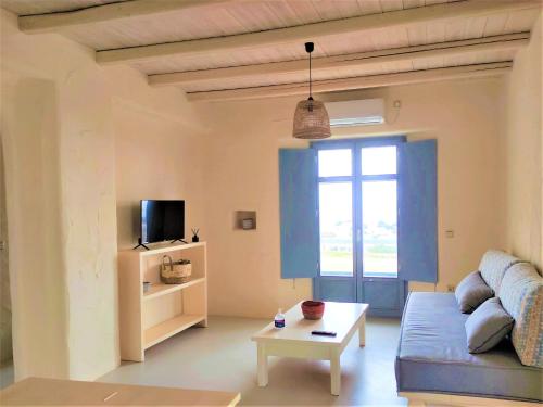 ein Wohnzimmer mit einem Sofa und einem Tisch in der Unterkunft Mosaic Suites in Drios
