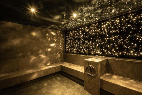 a room with a tub with lights on the wall at Moselschlösschen Spa & Resort in Traben-Trarbach