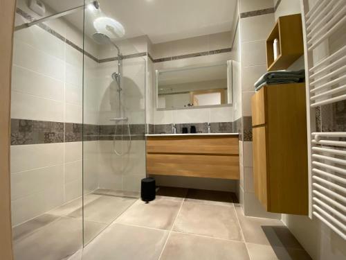 een badkamer met een glazen douche en een wastafel bij L'Escampette, superbe appartement avec terrasse in Gérardmer