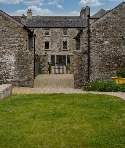 an external view of a stone building with a courtyard at Stay Barrow Blueway - The Stables in Monasterevin