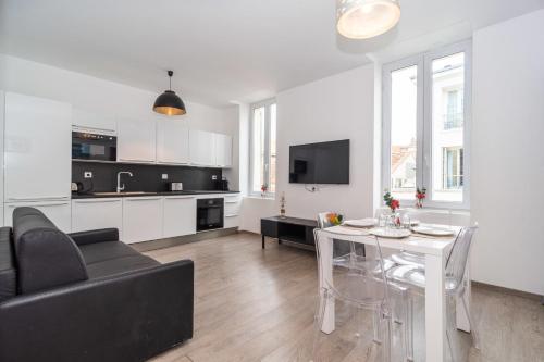 - un salon avec un canapé noir et une table blanche dans l'établissement Cosy 1BR Cannes Gambetta hyper centre - Croisette 1 mn - 4 pers by Olam Properties, à Cannes