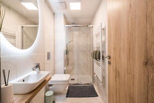 een badkamer met een toilet, een wastafel en een douche bij MF Coral 64 Premium Apartment in Siófok