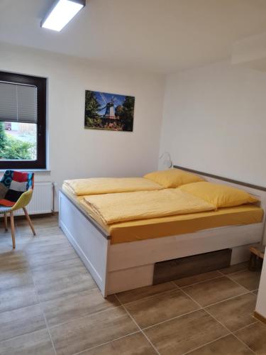 a bedroom with a bed in a white room at Ferienwohnung am Rüstersieler Hof in Wilhelmshaven
