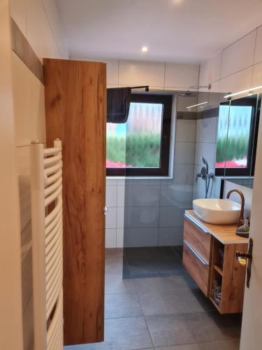 a bathroom with a sink and a toilet and a mirror at Ferienwohnung am Rüstersieler Hof in Wilhelmshaven