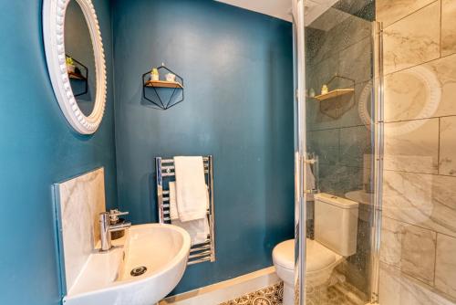 a blue bathroom with a sink and a shower at Guest Homes - Shaw Street Apartment in Worcester